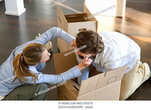 Couple playing in cardboard box