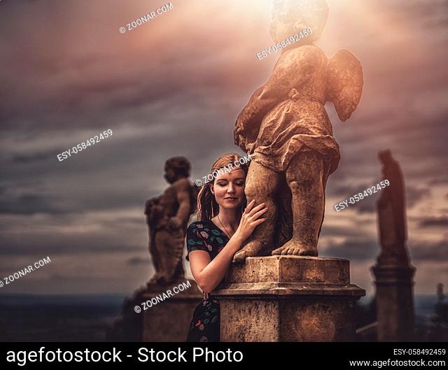 beautiful fashion model near an angel statue