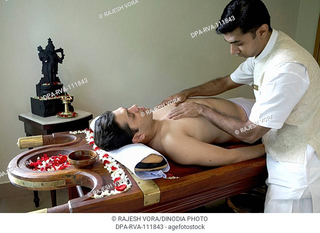 A patient being given an ayurvedic Kerala therapy by an expert at jiva health spa , Mumbai Bombay , Maharashtra , India