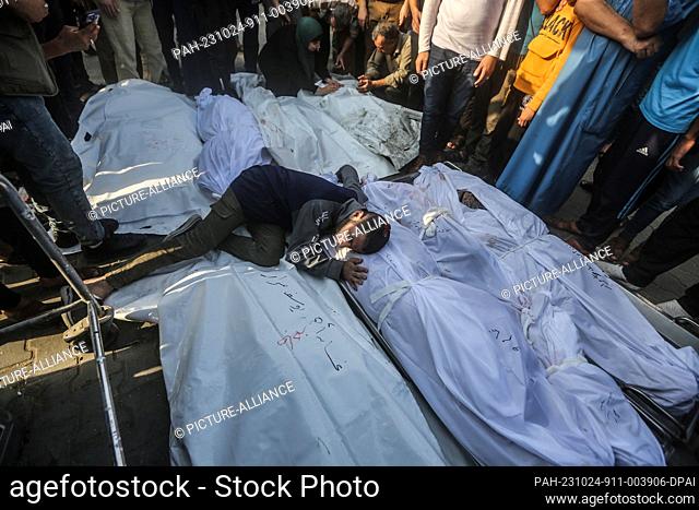 24 October 2023, Palestinian Territories, Khan Yunis: A Palestinian grieves beside the bodies of members of the Saqallah family