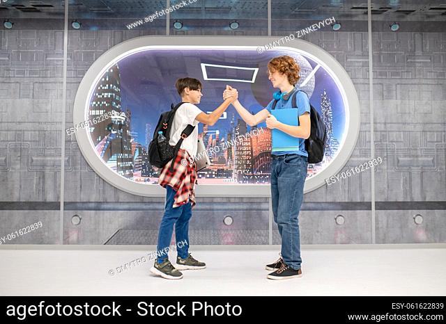 Handshake. Two boys shaking hands and looking joyful