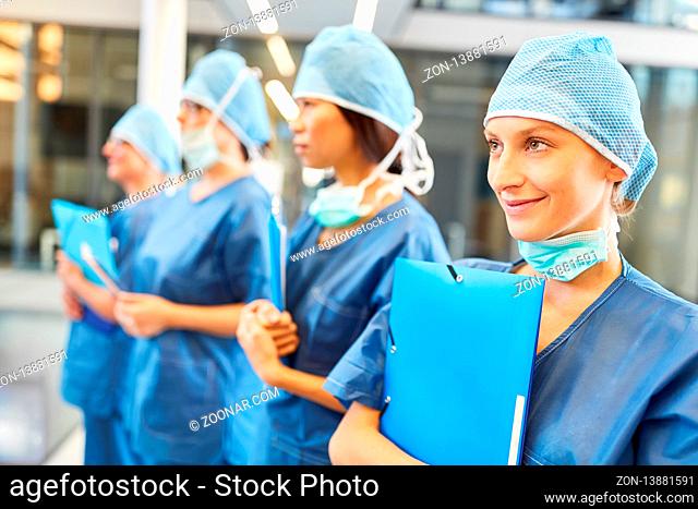 Chirurgie Team mit junger Ärztin in der Ausbildung in blauer OP-Kleidung in Notaufnahme
