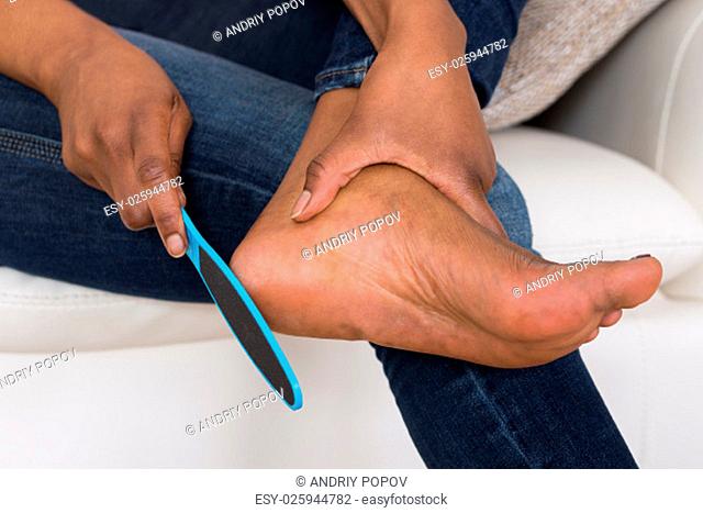 Close-up Of Person's Hand Pedicuring Her Legs