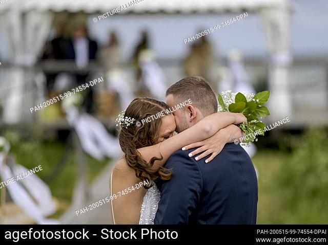 15 May 2020, Schleswig-Holstein, Stein: 23-year-old Lisann Camara and her husband Erik Camara hug each other after their wedding ceremony on the beach of the...