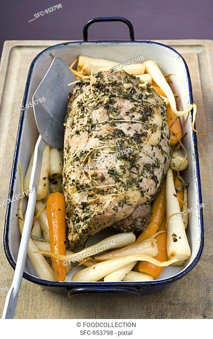 Rolled pork roast with herbs, carrots, parsley roots