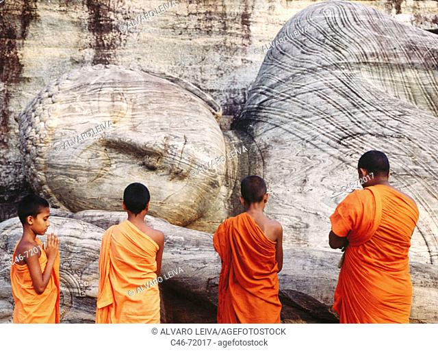 Monks praying at dawn in Gal Vihara temple, Polonnaruwa. Sri Lanka