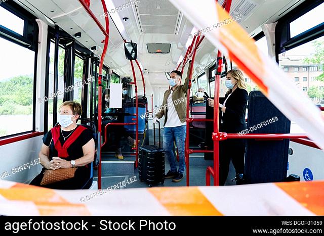 Passengers wearing protective masks in public bus, Spain
