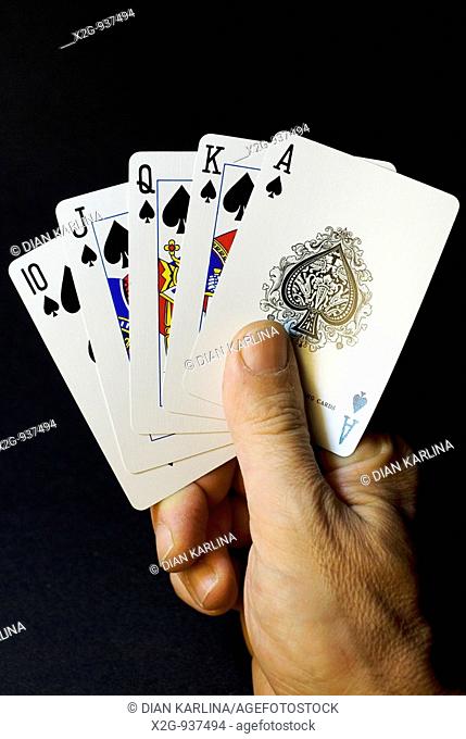 A male hand holding play cards