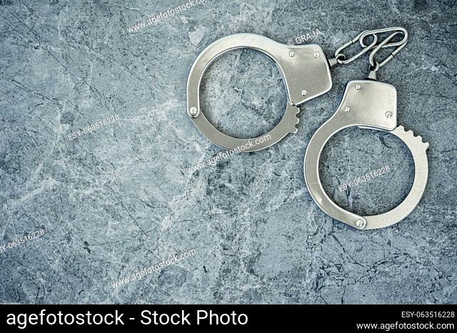 Closed handcuffs on the cement background. Copy space