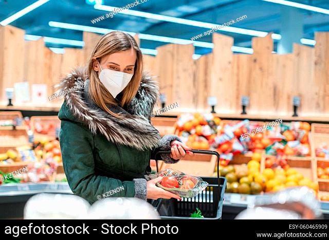 Woman wearing ffp2 face mask shopping groceries in supermarket