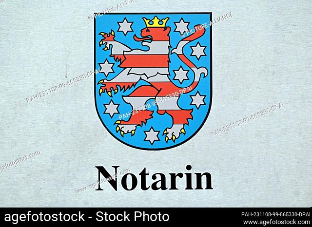 FILED - 07 November 2023, Thuringia, Erfurt: Notary and the Thuringian coat of arms can be seen on the sign in Erfurt city center