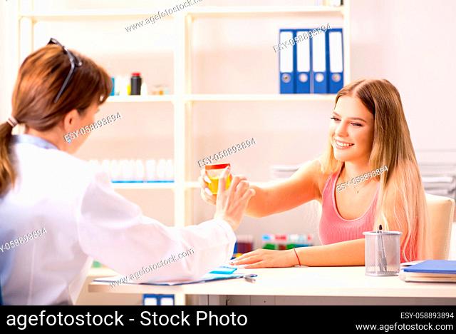 Young beautiful woman giving urine test to doctor