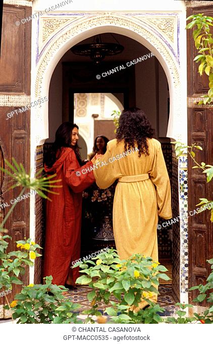MAGHREB WOMEN WEARING CAFTANS AND DJELLABAS IN THE COURTYARD OF A RIAD, MARRAKECH, MOROCCO, AFRICA