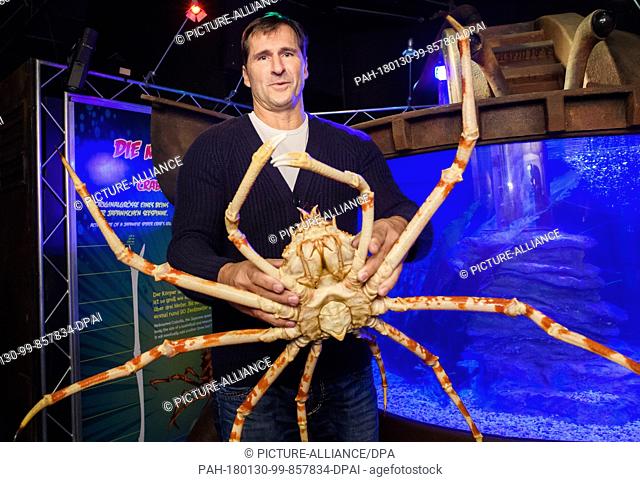 Lars Riedel, former Olympic champion and five-time discus throw World Champion, holding a Japanese spider crab during the inauguration of the special exhibition...