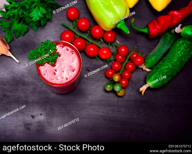 Tomato juice in a glass decorated with a sprig of parsley, top view