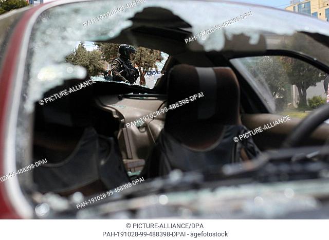 28 October 2019, Bolivia, La Paz: A policeman can be seen through the damaged windows of a car. A group of anti-government demonstrators blocked roads and...