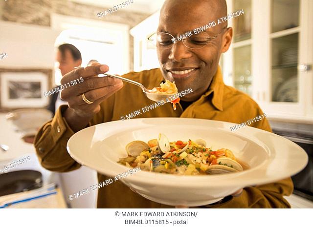 African American man eating seafood stew