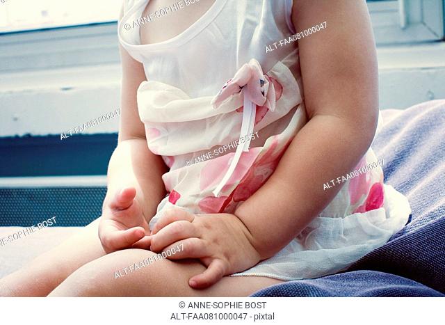 Little girl with hands clasped, dressed in underwear, cropped