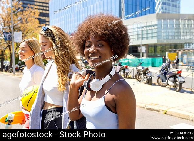 Smiling woman with female friends during sunny day