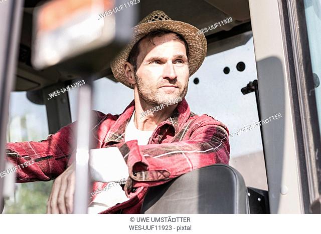 Portrait of confident farmer on tractor