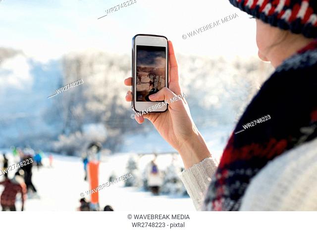 Woman photographing skiers at ski resort