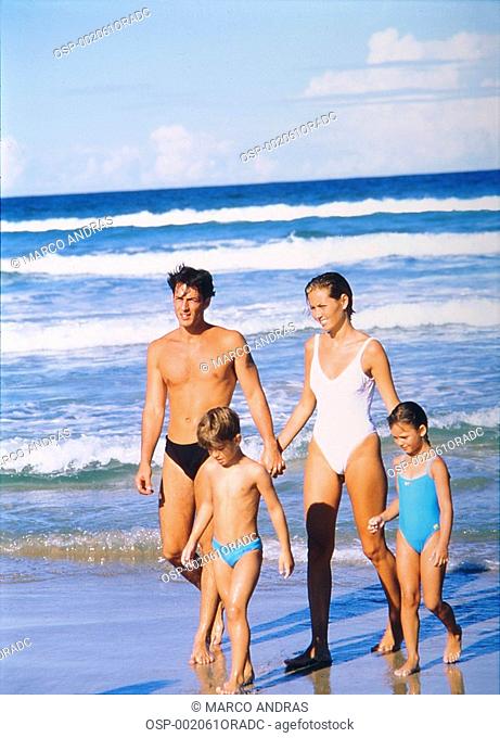 a family taking a walk at the beach shore