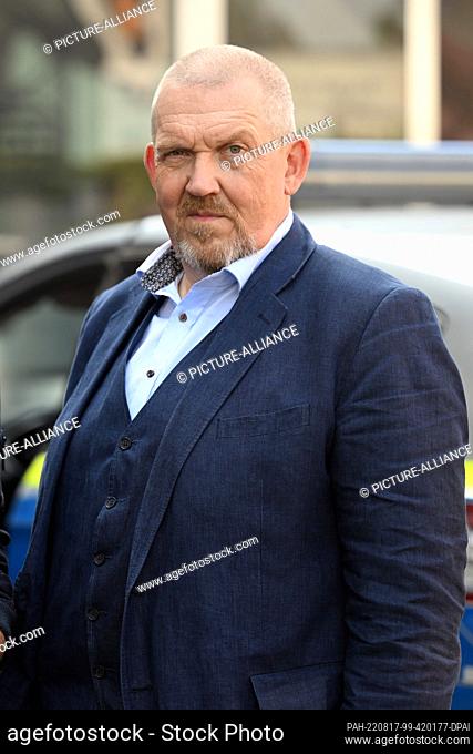 17 August 2022, North Rhine-Westphalia, Cologne: Actor Dietmar Bär as Freddy Schenk stands in front of a police car on the set