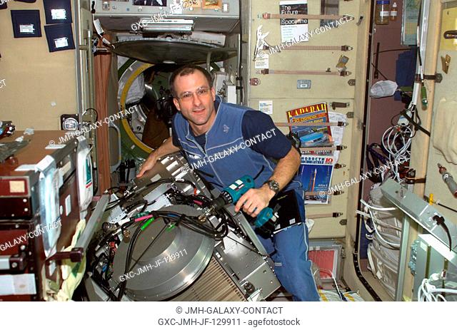 Astronaut Donald R. Pettit, Expedition Six NASA ISS science officer, performs in-flight maintenance (IFM) on the Treadmill Vibration Isolation System (TVIS) in...