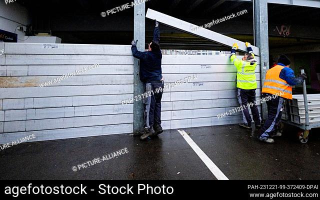 21 December 2023, North Rhine-Westphalia, Duesseldorf: City employees close the gate at the Lower Rhine Wharf to the Old Port