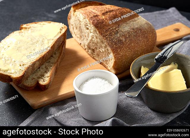 close up of bread, butter, knife and salt on towel