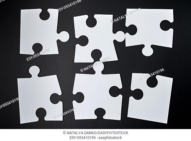 white big puzzles on a black background. Concept in business