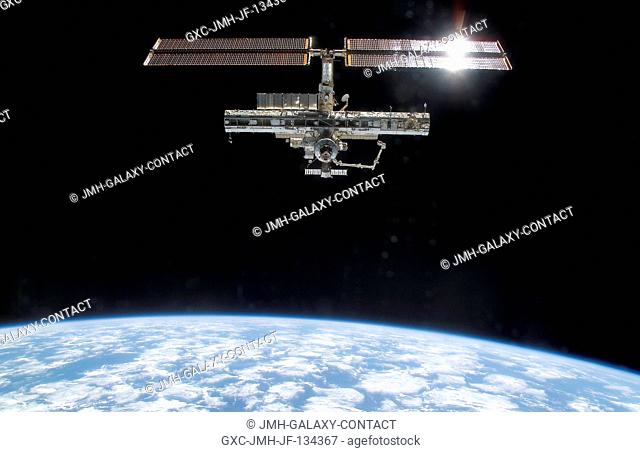 Backdropped by the blackness of space and Earth's horizon, this full view of the International Space Station (ISS) was photographed by a crewmember on board the...