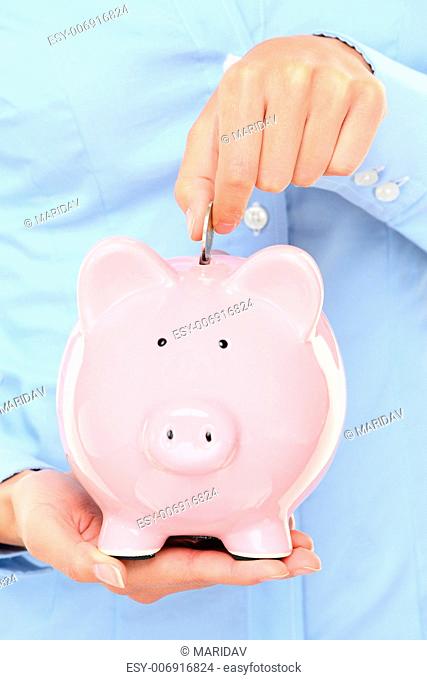 Piggybank money concept. Savings and financial concept closeup of business woman hand putting money in piggy bank savings