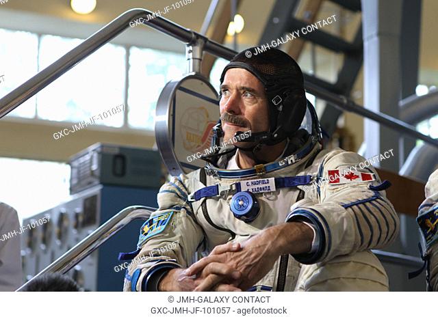 Expedition 3233 backup crew member Chris Hadfield of the Canadian Space Agency strikes a pose during a photo session with the media at a Soyuz vehicle mock-up...