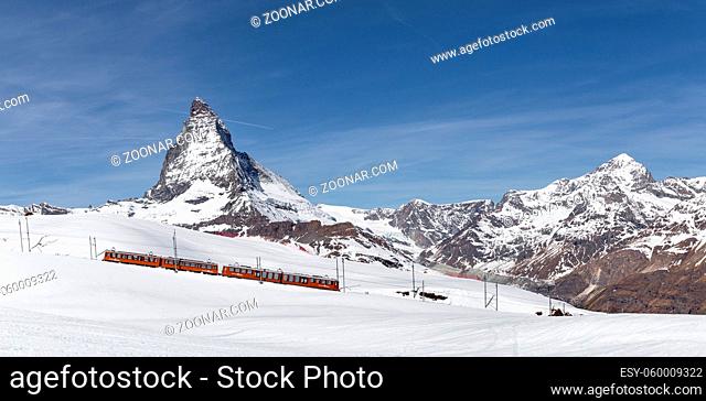 Zermatt, Switzerland - April 12, 2017: A red train in front of the snowy Matterhorn mountain