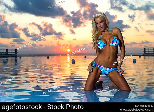 A bikini model posing at sunrise