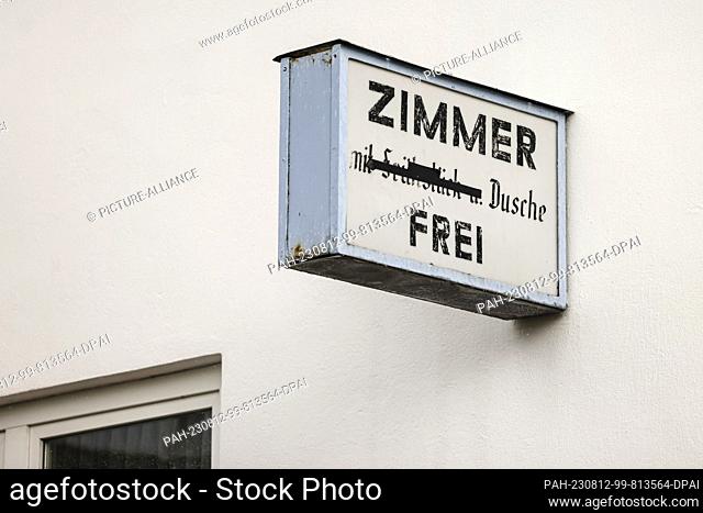 PRODUCTION - 08 August 2023, Schleswig-Holstein, Großenbrode: A sign reading ""Room shower"" free hangs on a house wall. Many guests are not as flush with cash...