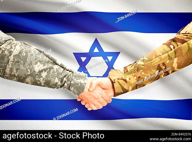 Soldiers shaking hands with flag on background - Israel