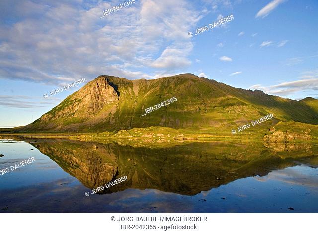 Reflection of mountains in a shallow pond in Sandøya, Nordland, Norway, Europe