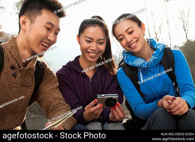 Friends looking at the picture on the screen of digital camera