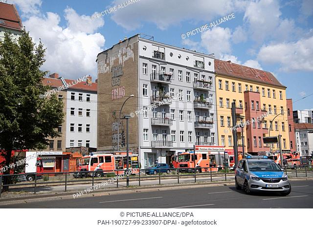 27 July 2019, Berlin: Firefighters are standing on the roof of an apartment building in Danziger Straße. A fire had broken out in an attic apartment of the...