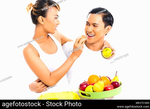 Asian couple eating fruit and living healthy