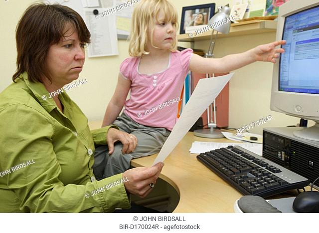 Mother in office trying to work being disturbed by daughter