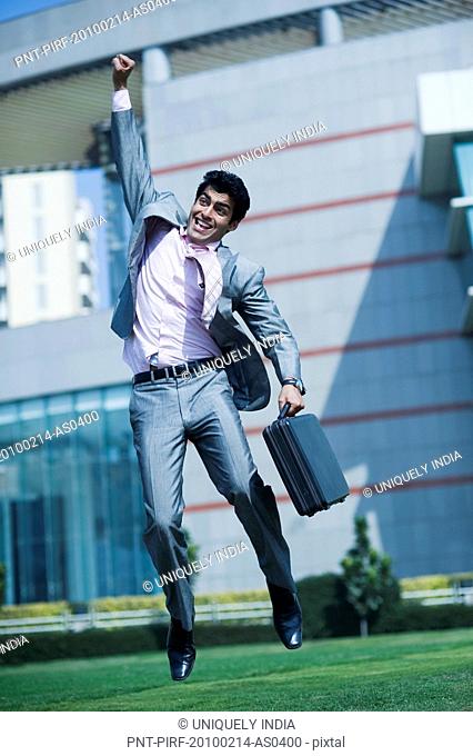 Businessman jumping up with a briefcase in hand, Gurgaon, Haryana, India