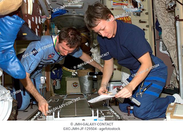 Cosmonaut Sergei Y. Treschev (left) and astronaut Peggy A. Whitson, both Expedition Five flight engineers, perform maintenance on the Treadmill Vibration...
