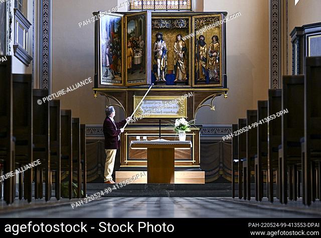 24 May 2022, Saxony-Anhalt, Köthen: District Chief Pastor Lothar Scholz opens the festival side of the late Gothic high altar in the Lutheran Church of St