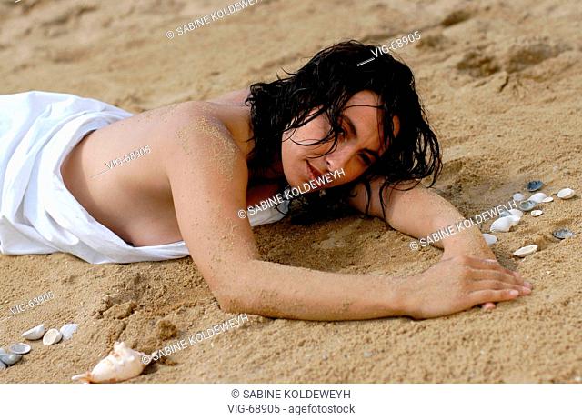 Young, darkhaired woman lying in the sand. - 18/08/2004