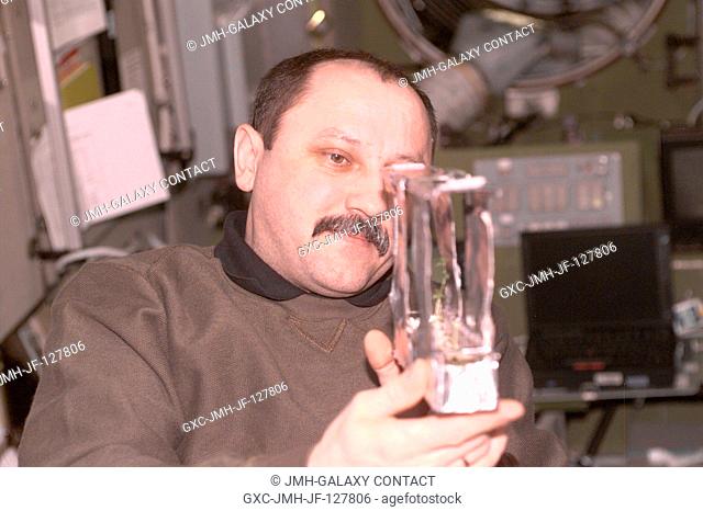 Yury V. Usachev of Rosaviakosmos, Expedition Two mission commander, examines a plant experiment in the Zvezda Service Module