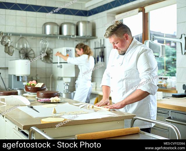 Confectioner preparing marzipan sticks at kitchen