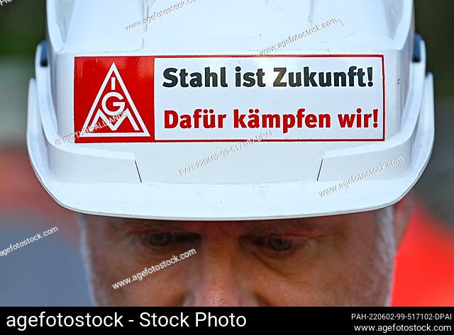02 June 2022, Brandenburg, Eisenhüttenstadt: During a warning strike, a steelworker from ArcelorMittal Eisenhüttenstadt GmbH wears a hard hat with the...